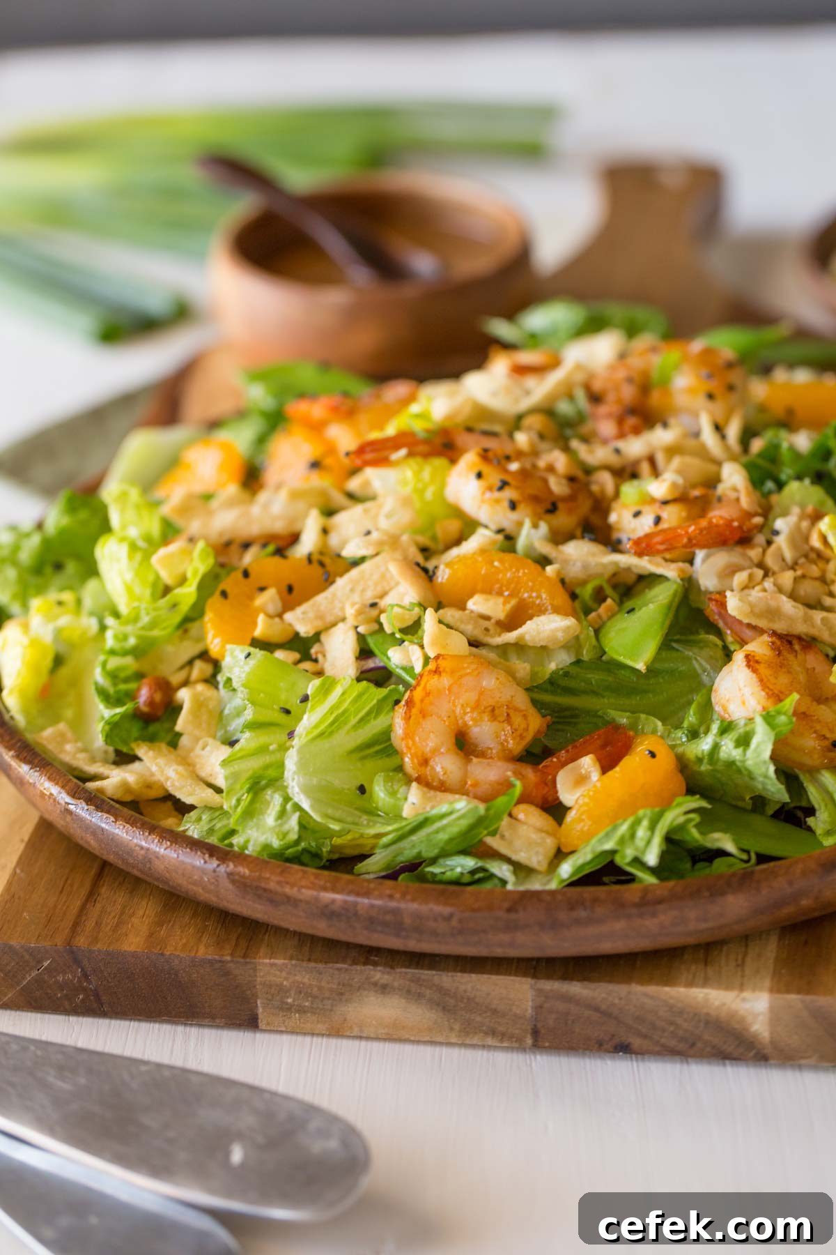 Shrimp Salad on a large serving plate, with a small wood bowl of the Spicy Peanut Dressing in the background.