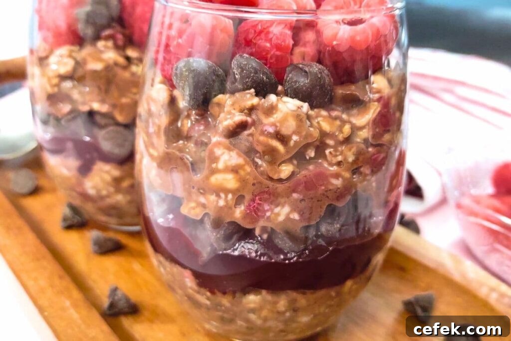 Raspberry Chocolate Overnight Oats Recipe for Morning Boost 3 seeing the layers in a glass filled with raspberry chocolate overnight oats