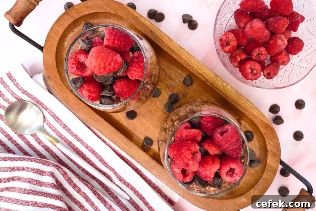 Raspberry Chocolate Overnight Oats Recipe for Morning Boost 7 overhead view of raspberry chocolate overnight oats in a glass with fresh fruit and chocolate surrounding