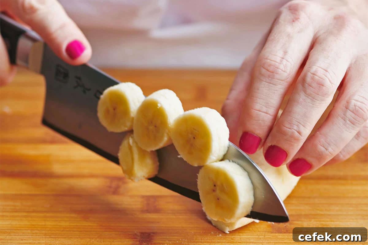 Woman slicing bananas on cutting board.