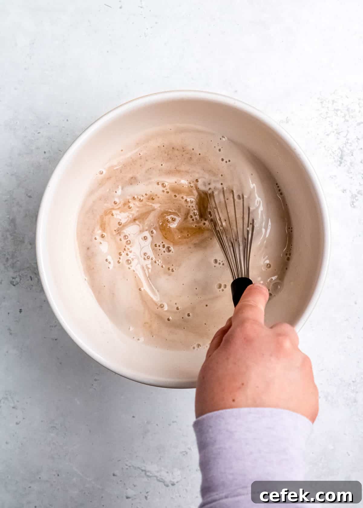 wet ingredients mixed together in a white bowl with a whisk