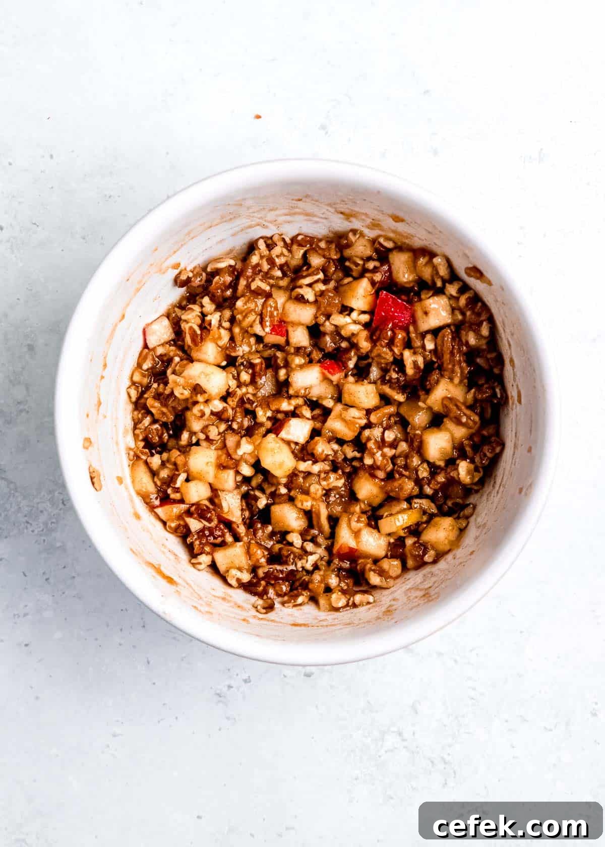 pecans, apples, maple syrup, melted butter, and apple pie spice in a mixing bowl