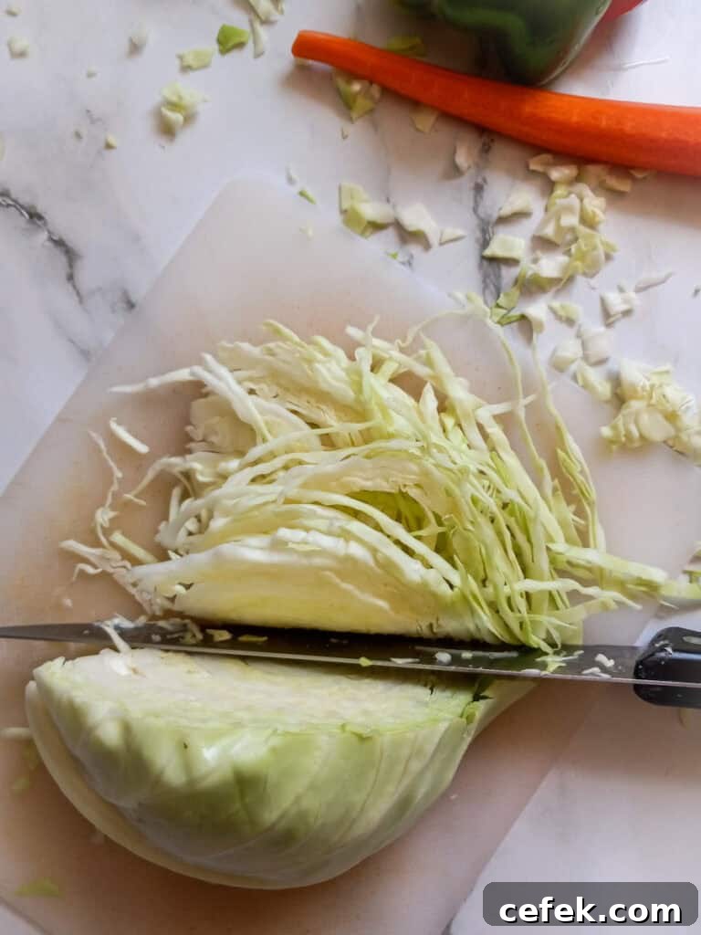 Amish Pepper Cabbage: Tangy Country-Style Side Dish 3 thinly slicing cabbage on a cutting board.