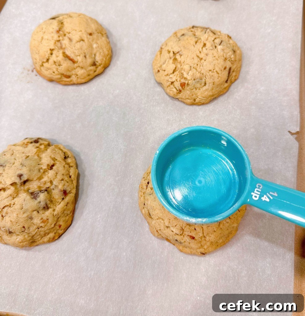 Making a well in the center of the cookies using a small measuring cup.