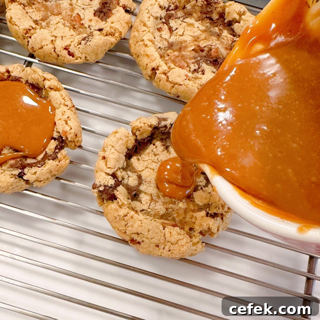 Pouring caramel into the center of each cookie.