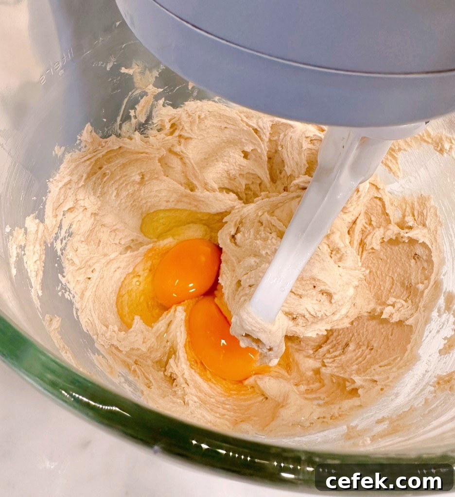 Adding Eggs one at a time until combined with sugar and butter.