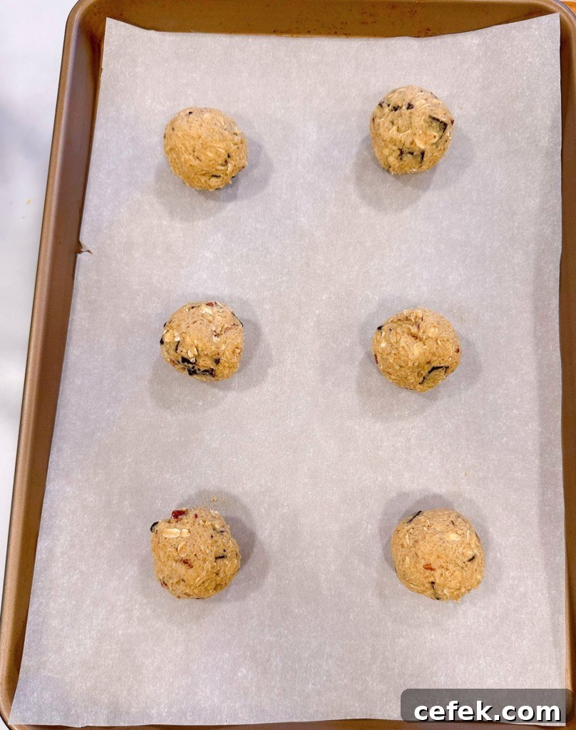 Cookie dough arranged on cookie sheet, rolled into balls.