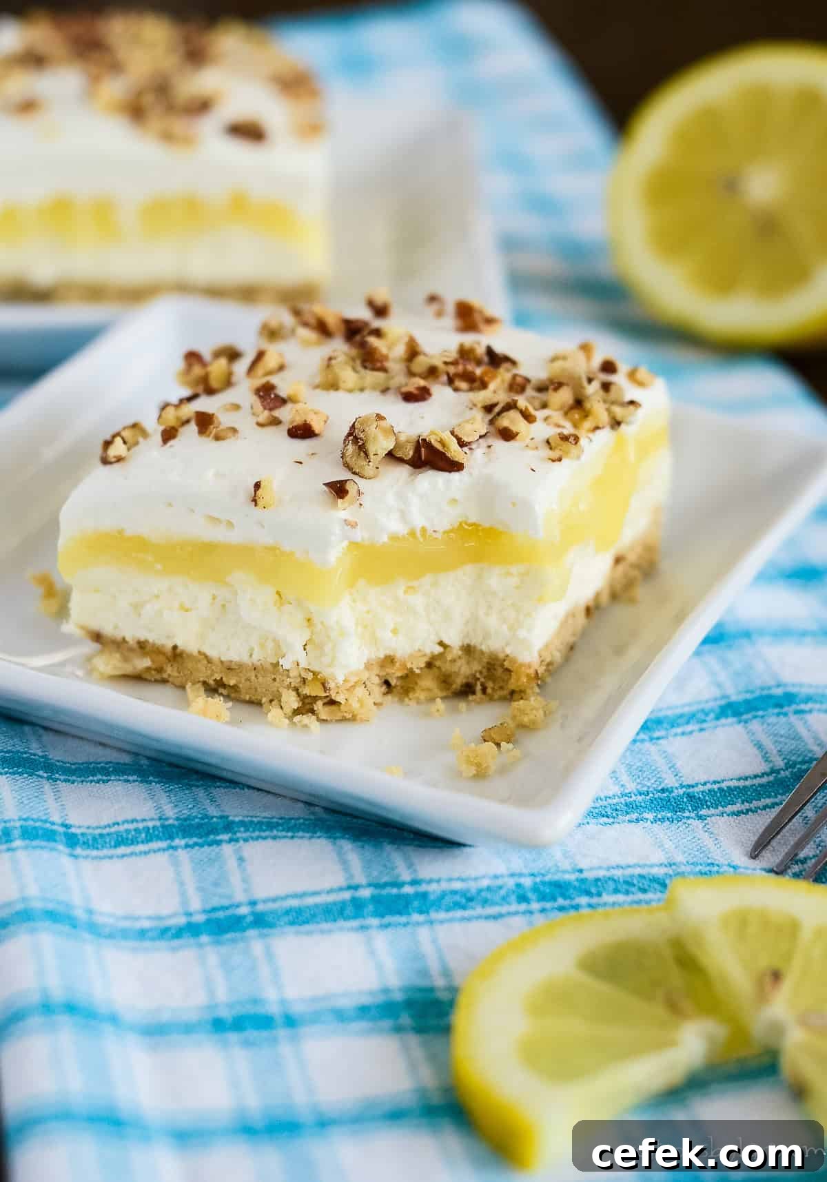 Lemon Lush Dessert Recipe: Creamy Layered Lemon Bars 8 slice of lemon lush with a bite taken out of it