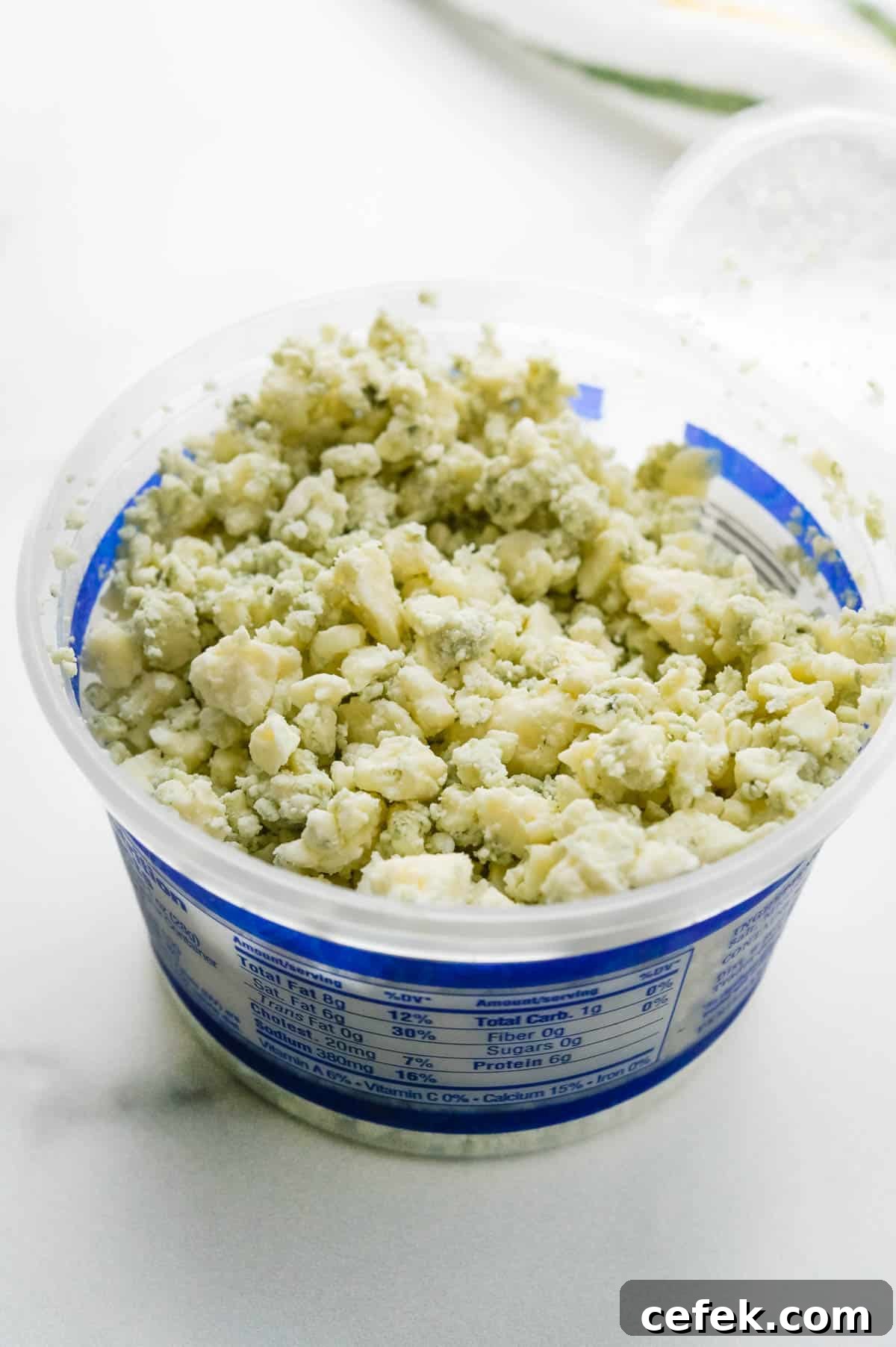 Homemade Chunky Blue Cheese Dressing for Wings and Salads 2 A container of blue cheese crumbles.
