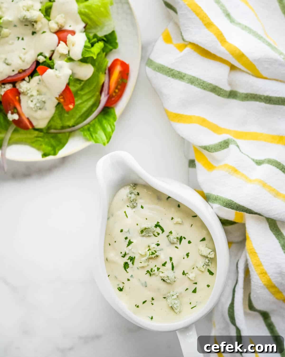 Homemade Chunky Blue Cheese Dressing for Wings and Salads 7 A green salad with a pitcher of blue cheese dressing on the side.