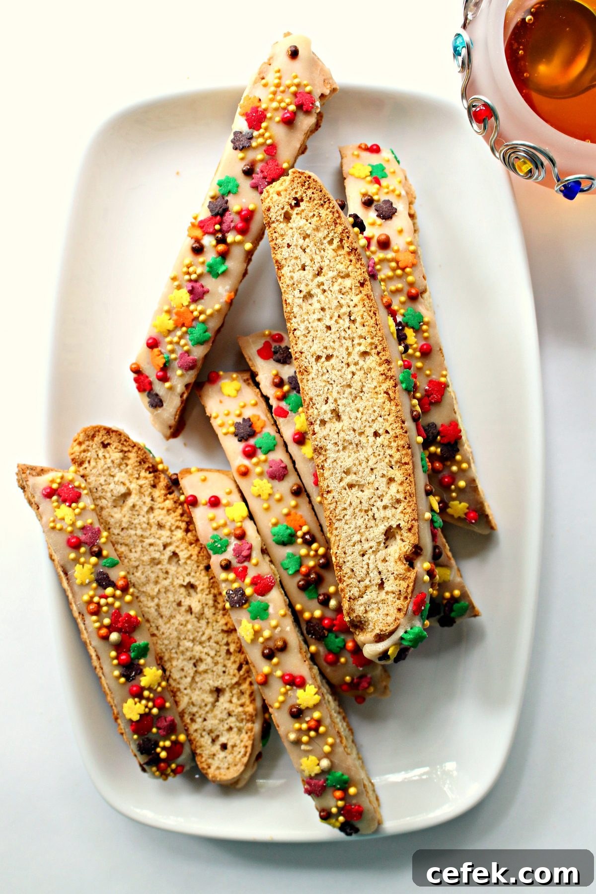 Iced and sprinkled biscotti on a white serving platter.