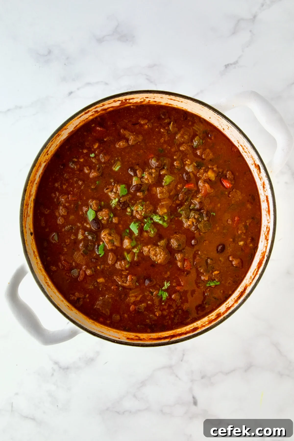 Finished chili in white enamel Dutch oven.