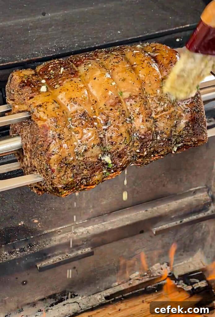 Rotisserie Prime Rib: How to Cook a Tender, Juicy Roast 16 basting a prime rib roast while it's on the rotisserie over a fire