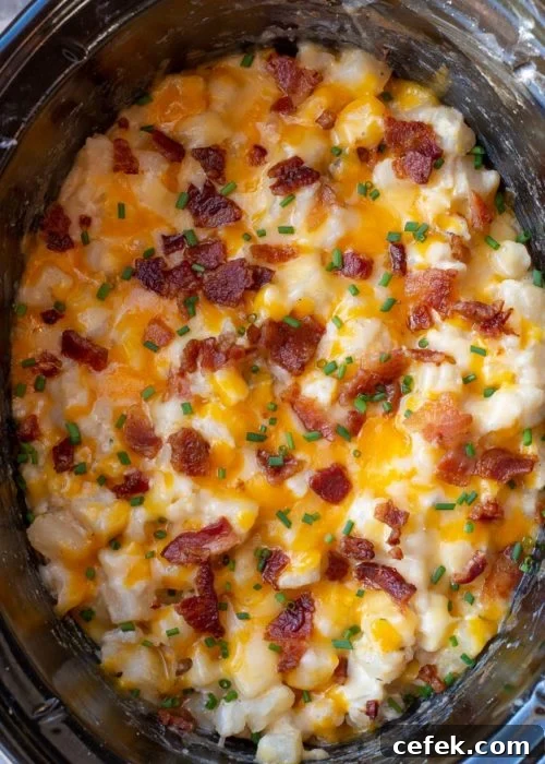 Creamy Cheddar Slow Cooker Potatoes 6 Serving spoon scooping cheesy potatoes