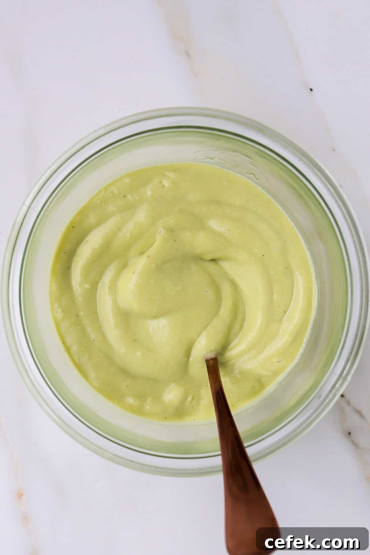 White Bean and Kale Salad with Creamy Avocado Dressing 6 Avocado dressing in a jar with a spoon.