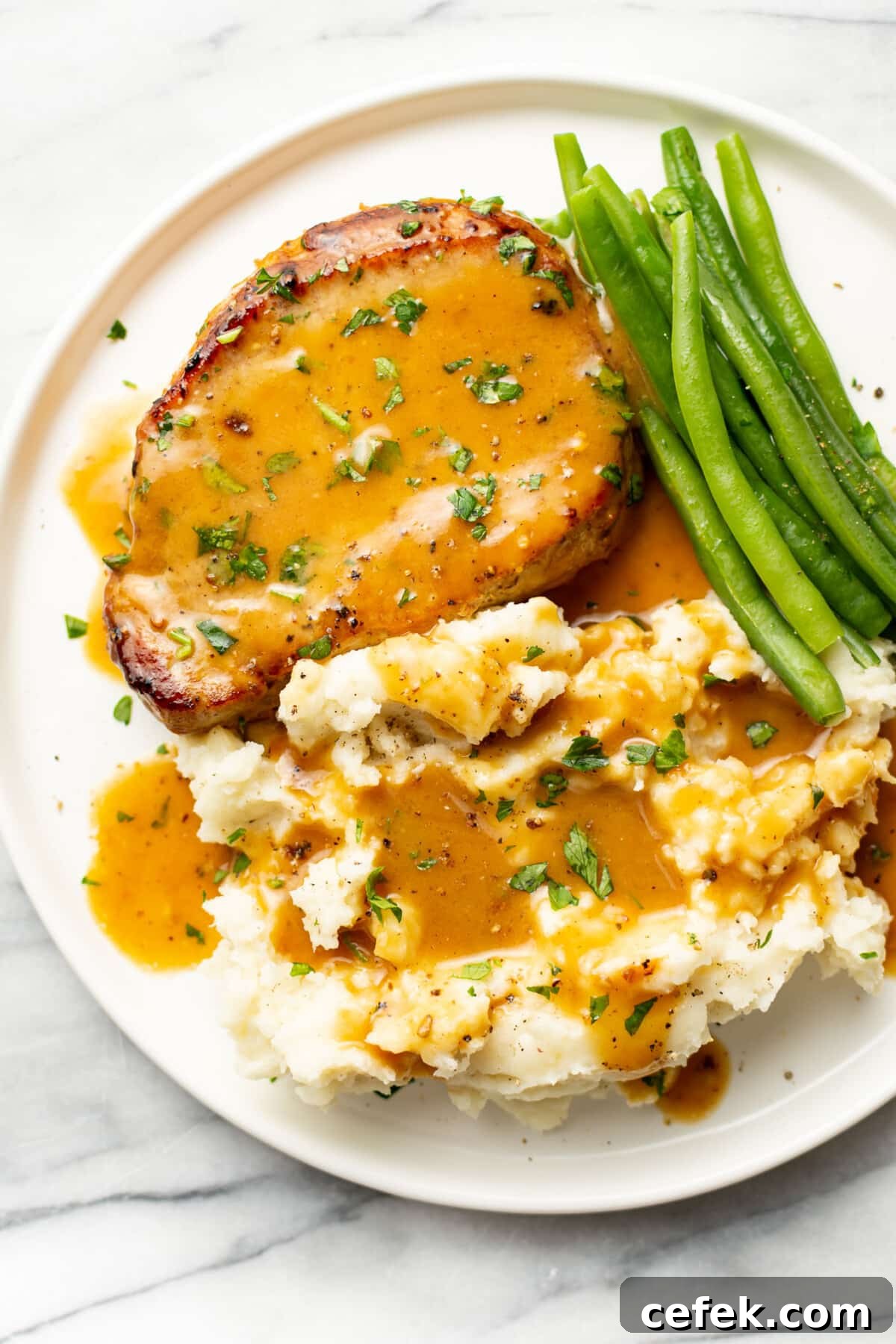 Honey Mustard-Glazed Pork Chops 2 a plate with honey mustard pork chop, green beans, and mashed potatoes