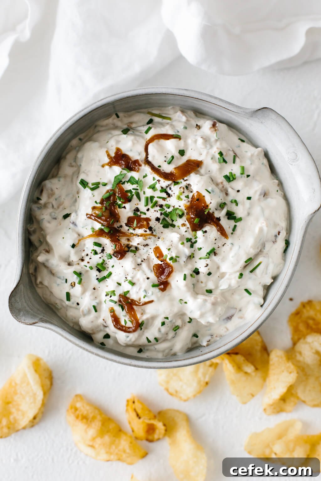 Gluten-Free Thanksgiving Menu: Recipes for a Festive Feast 17 French onion dip in a ceramic bowl with potato chips next to it.