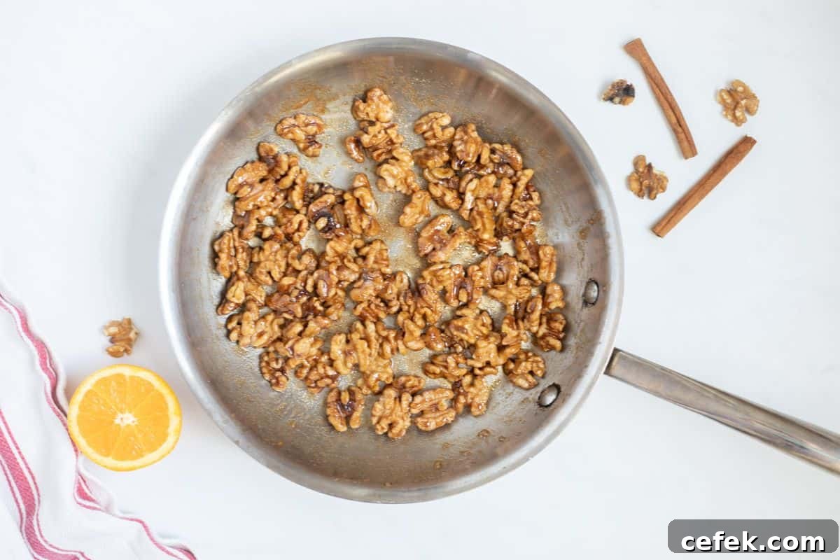Sweet and Spicy Candied Walnuts Walnuts coated with orange juice, orange zest, brown sugar, white sugar, cinnamon, salt, and cayenne in stainless steel skillet.